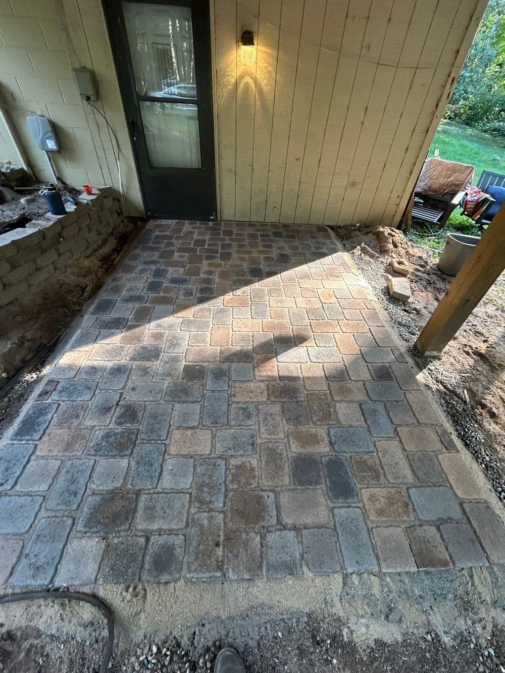 Newly installed paver patio with warm lighting, showcasing a stylish outdoor space.